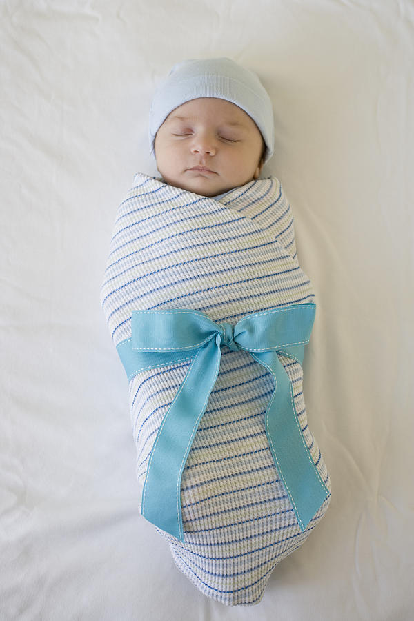Baby wrapped in blanket with bow Photograph by Tetra Images