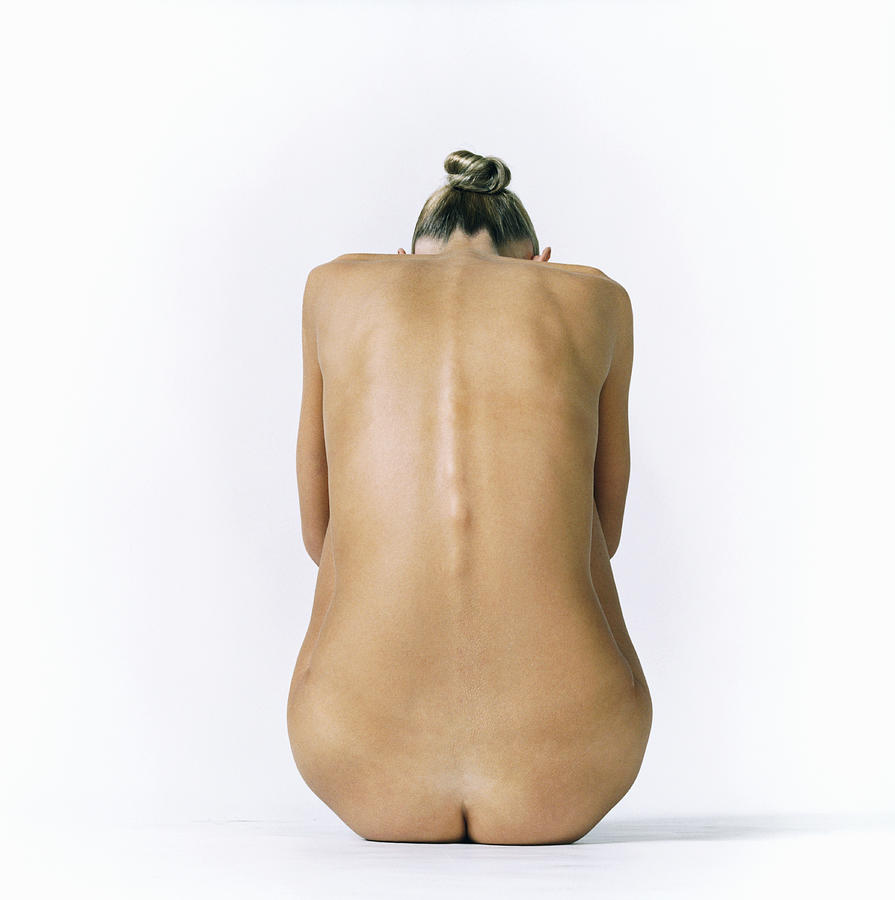 Back of a Naked Woman Sitting Down Photograph by Digital Vision.
