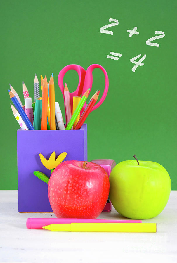 Back to school pencil box against green chalkboard. Photograph by Milleflore Images
