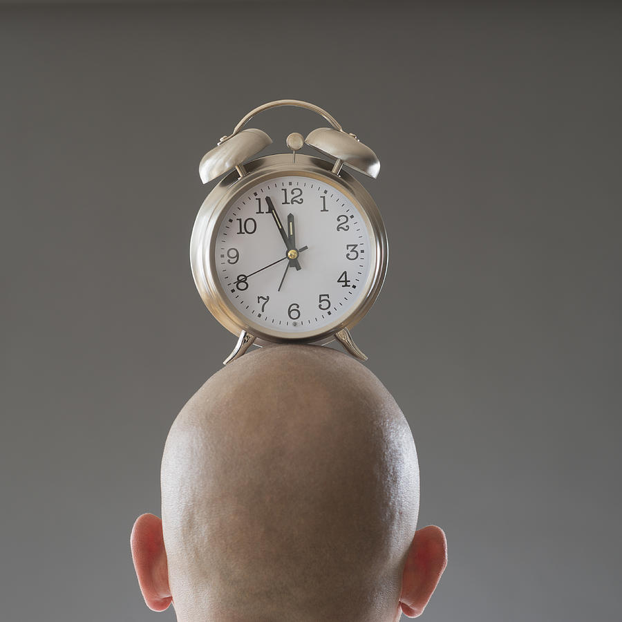 Back view of man with alarm clock on shaved head Photograph by Tetra Images