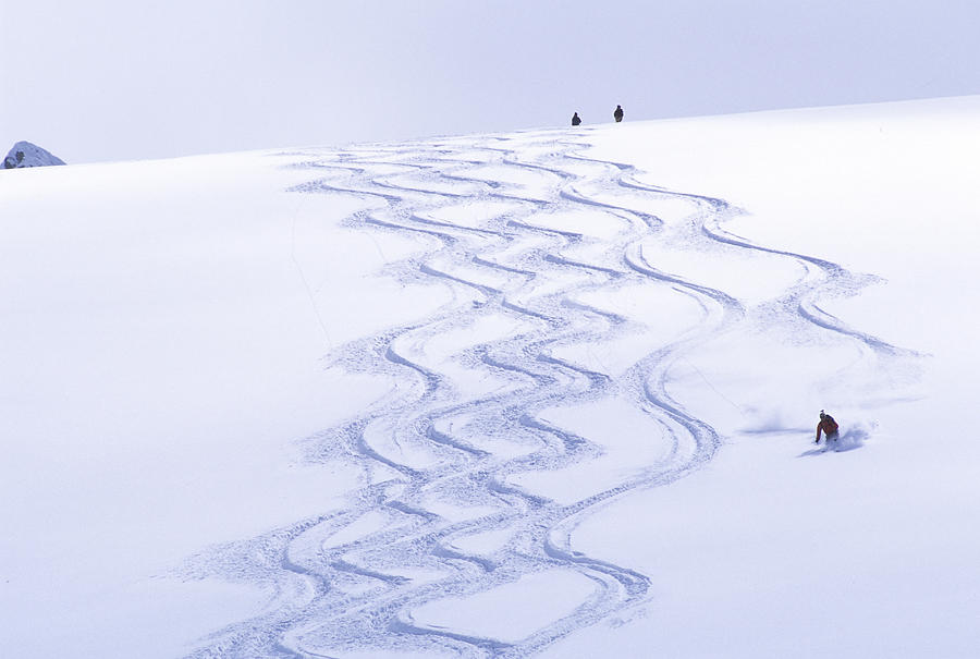 Backcountry skier matching tracks downhill. Photograph by Heath Korvola