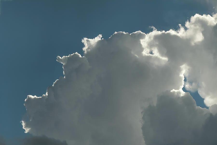 Backlit Cumulonimbus Clouds Against Clear Blue Sky Photograph