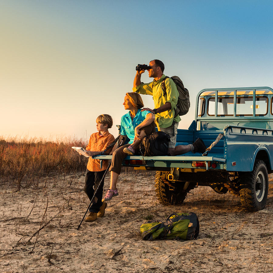 Backpacking family on vehicle at sunset Photograph by Stevecoleimages