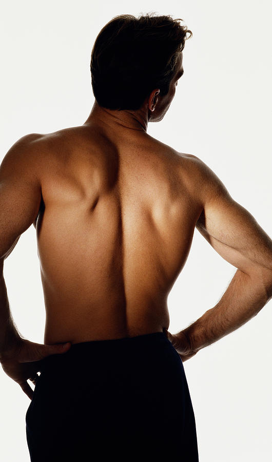 Backview Of A Shirtless Man With Arms Akimbo Photograph by Jan Cobb Photography Ltd.