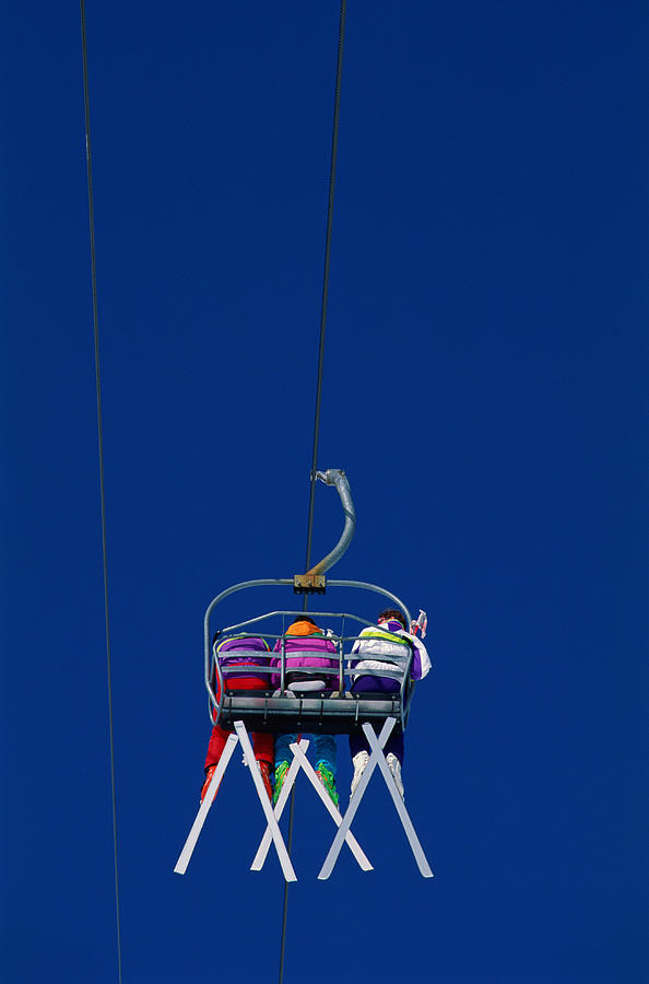 Backview Of Three Skiers On Chair Lift Photograph by Simon Wilkinson