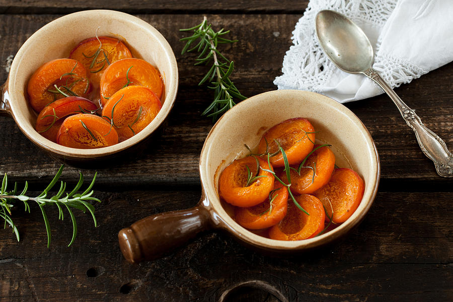 Baked peaches with honey and rosemary Photograph by Carolafink