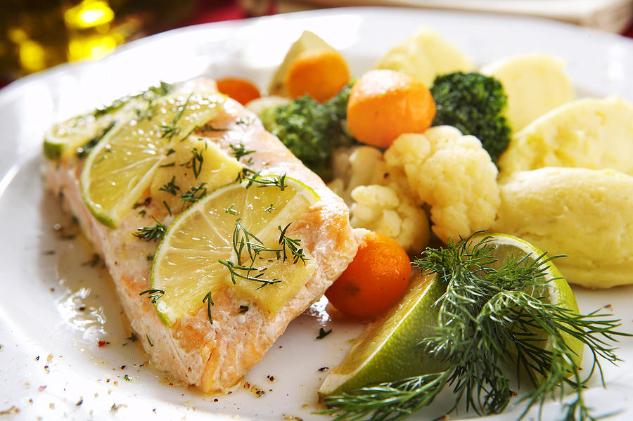 Baked salmon dish with assorted vegetables and lemon Photograph by ShyMan