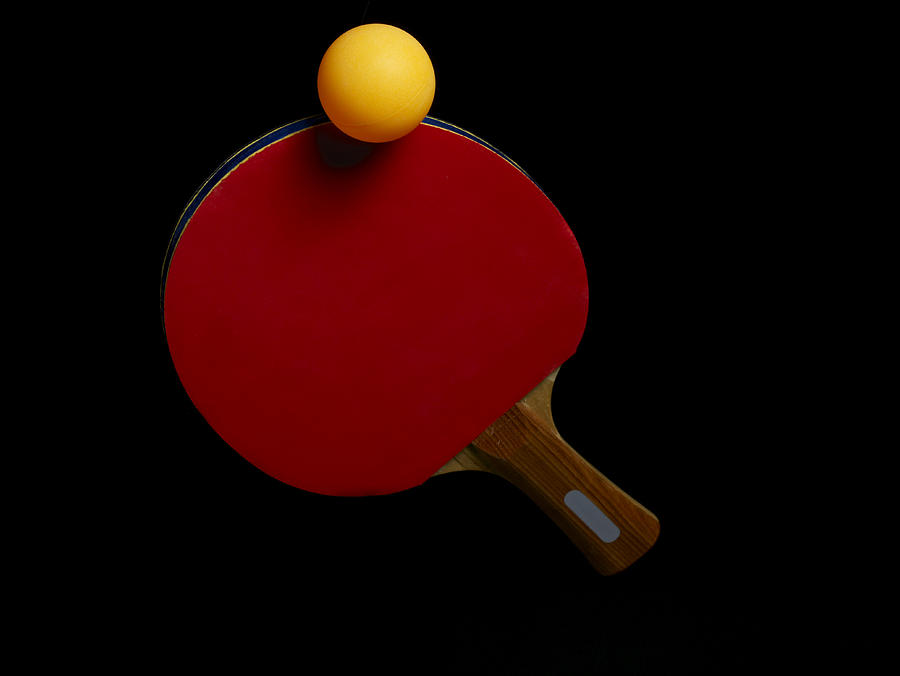 Ball balancing on table tennis bat, close-up, against black background Photograph by Jonathan Storey