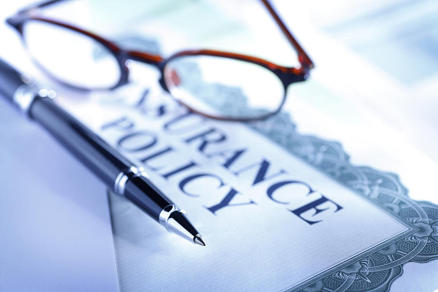 Ballpoint pen and eyeglasses on top of insurance policy Photograph by Dny59