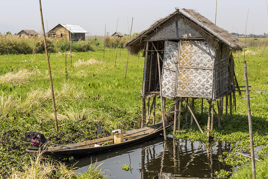 Bamboo hut on poles along river Photograph by Merten Snijders