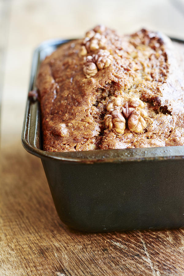 Banana bread with walnuts in a bread pan Photograph by Westend61