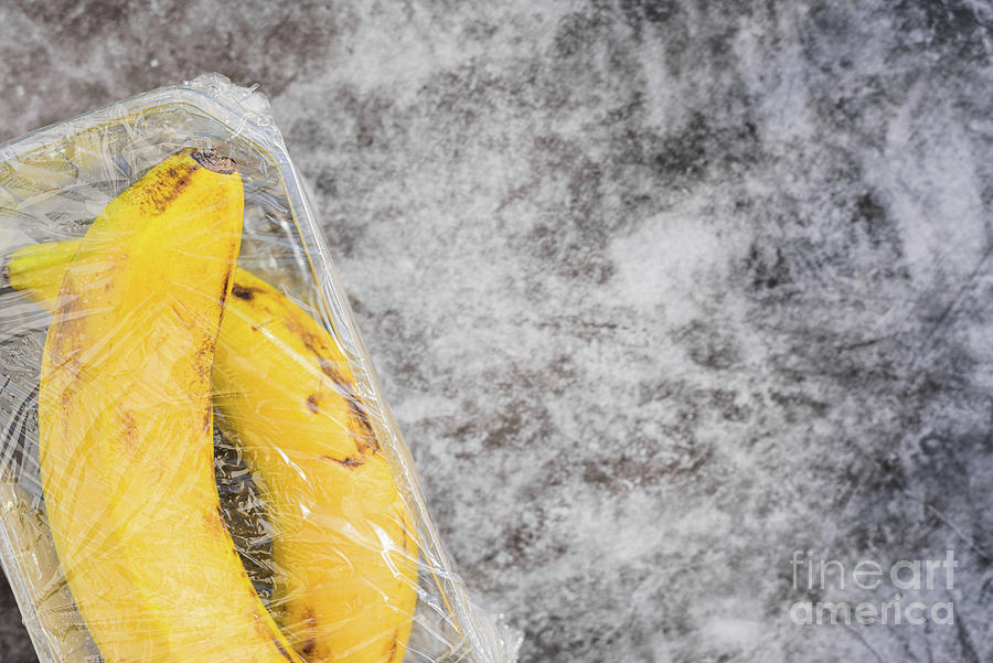 Bananas with natural peel wrapped in pointless plastic packaging Photograph by Joaquin Corbalan