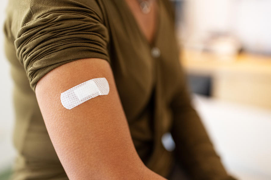 Bandage on arm of a female after taking vaccine Photograph by Luis Alvarez