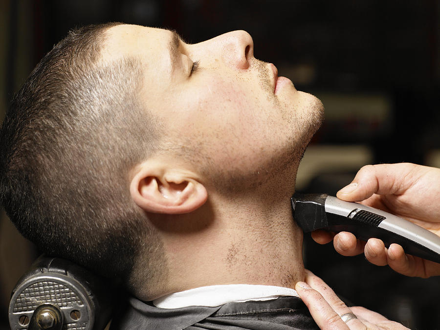 Barber shaving man, close-up, profile Photograph by Michael Blann