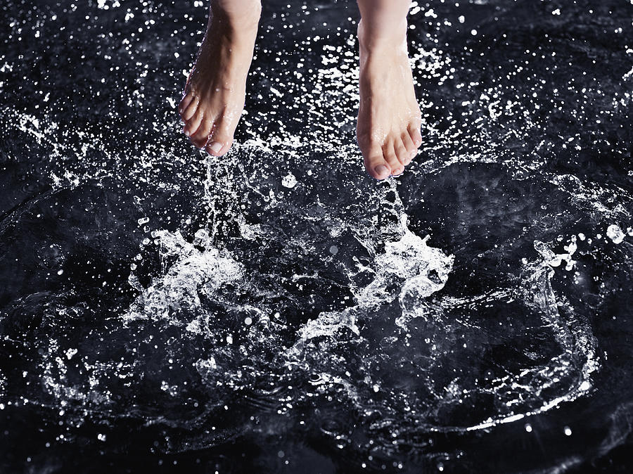 Bare feet splashing in water Photograph by Robert Daly