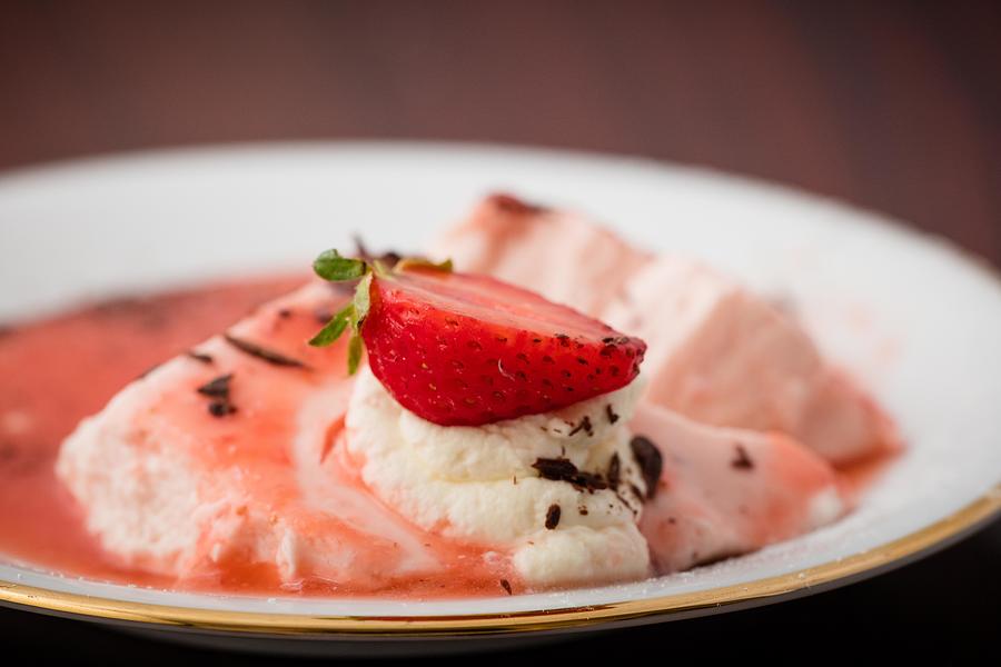 Bavarois with strawberry on white plate. Photograph by Annick Vanderschelden Photography
