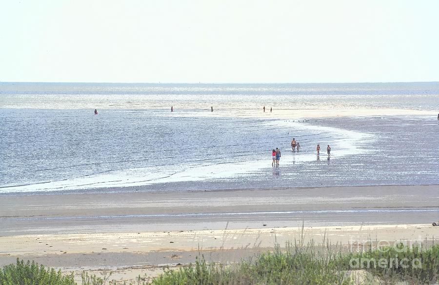 Beachgoers wade far offshore on sand bars during low tide at Jekyll Island Georgia USA Photograph by William Kuta