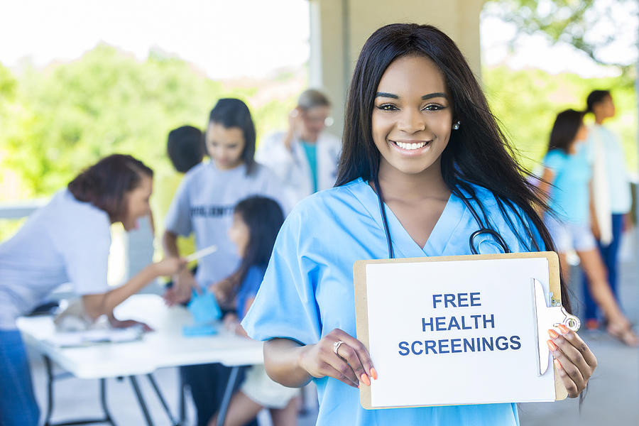 Beautiful African American Woman holding a Free Health Screenings sign Photograph by SDI Productions