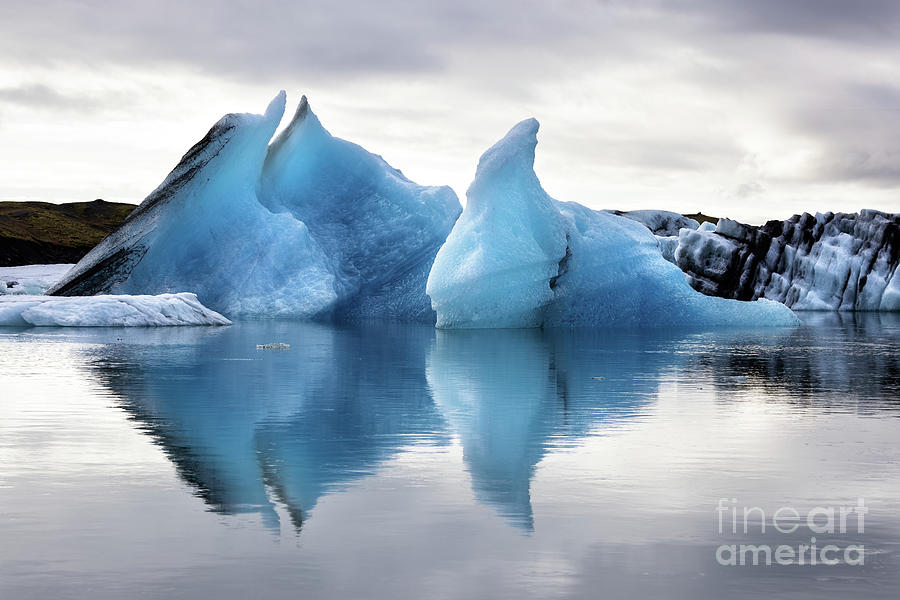 Beautiful blue icebergs reflected in the Jokulsarlon glacial lagoon, Southern Iceland. Part of the Vatnajokull National Park Photograph by Jane Rix