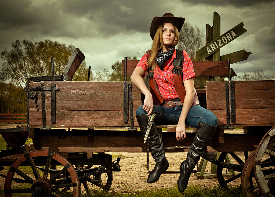 Beautiful cowgirl with gun on cowboy cart Photograph by Mordolff