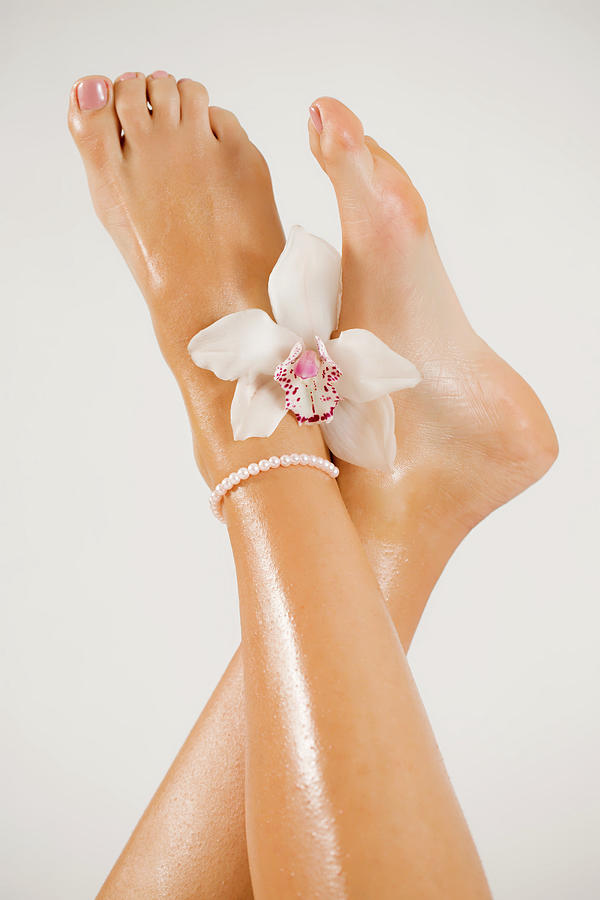 Beautiful female feet with orchid flower Photograph by Iuliia Malivanchuk