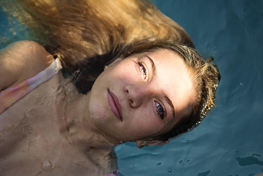 Beautiful portrait of teenage girl in pool water. Photograph by Martinedoucet