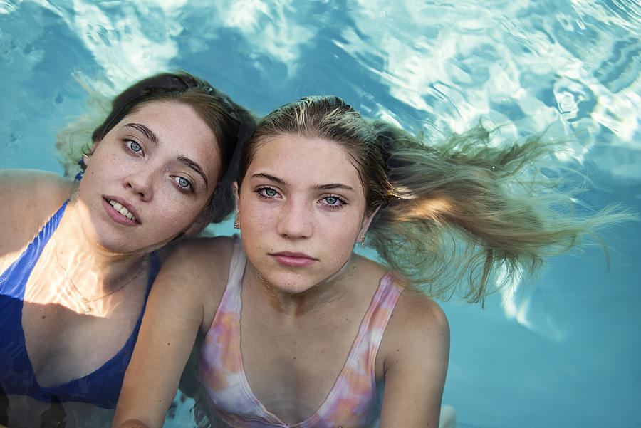 Beautiful portrait of two cousins in pool water. Photograph by Martinedoucet