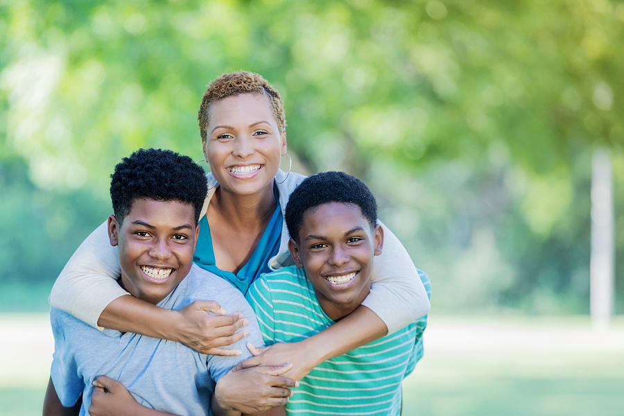 Beautiful single mom smiles for camera with two teenage sons Photograph by SDI Productions