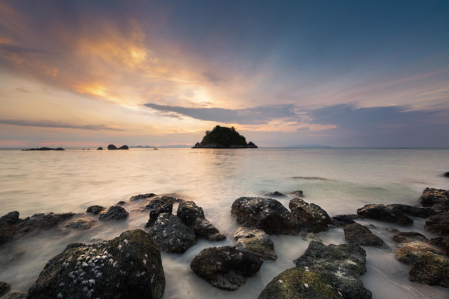 Beautiful sunrise on tropical white sand and rock near the Serendipity Beach Resort at Lipe Island, Satun Province, Thailand. Photograph by Pakphipat Charoenrach