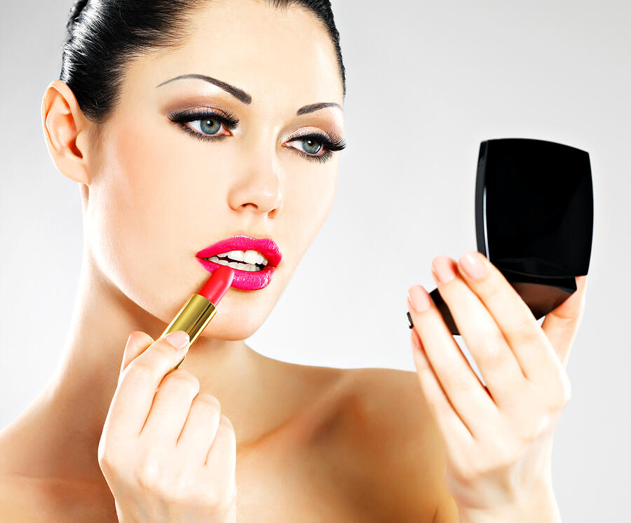 Beautiful woman applying pink lipstick on lips Photograph by ValuaVitaly
