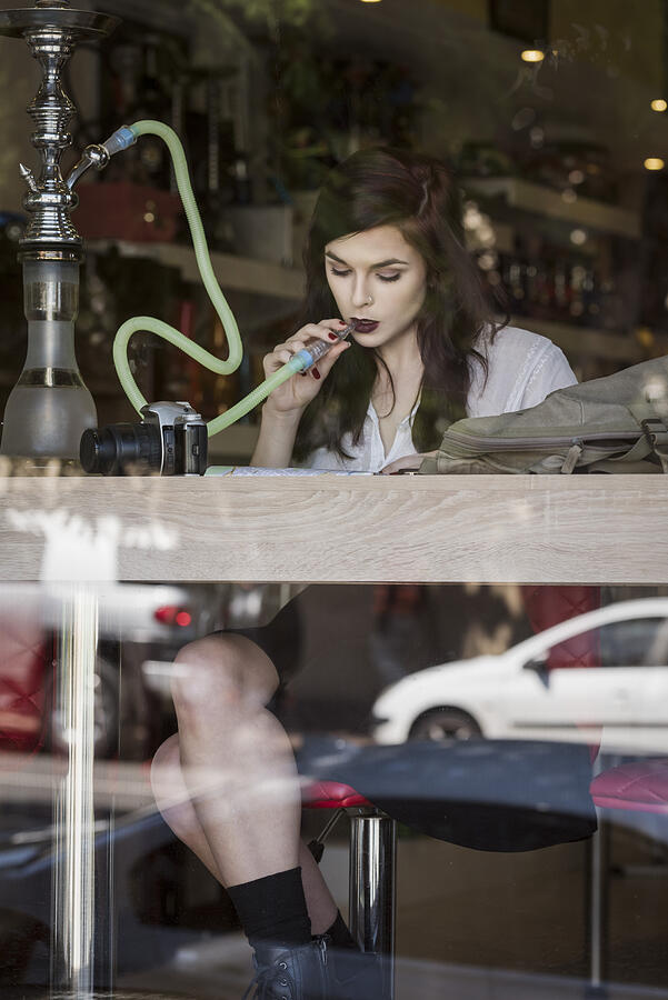 Beautiful Woman Sitting At Shop Window Smoking Photograph by GeoffGoldswain