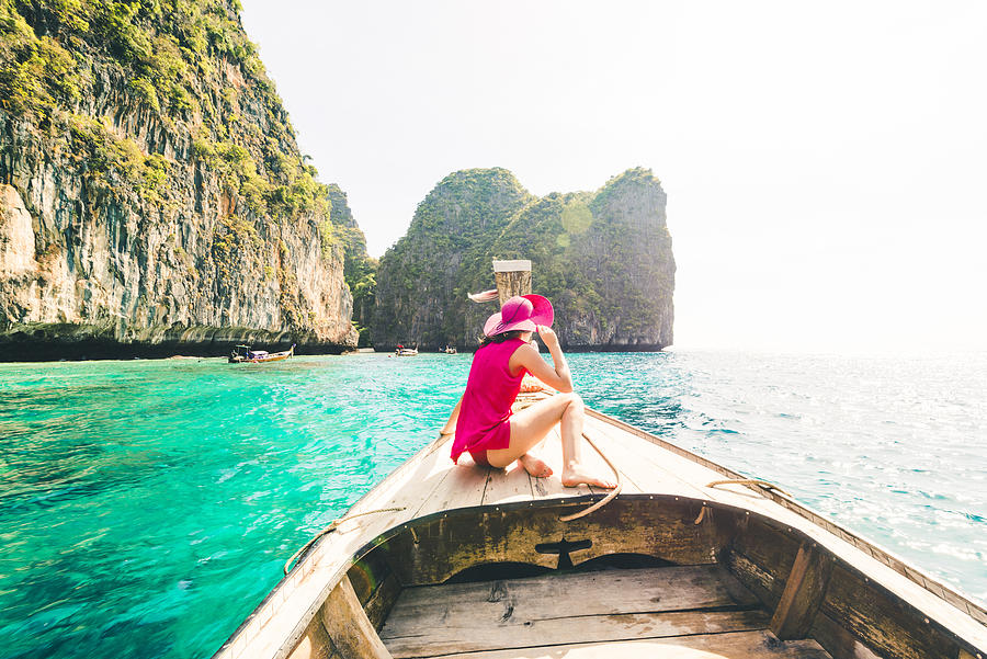 Beautiful woman sitting on longtail boat at Phi Phi Islands. Photograph by © Marco Bottigelli