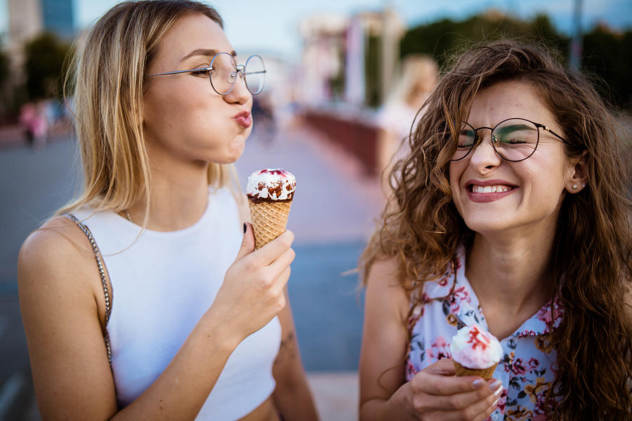 Beautiful women eating ice cream in walk Photograph by Johnce