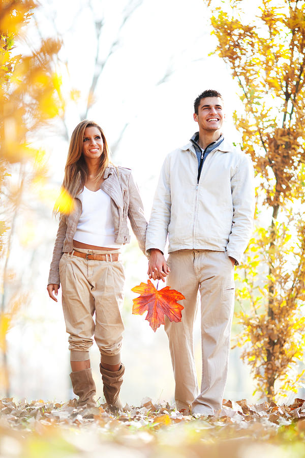 Beautiful young couple enjoying in the autumn day. Photograph by Skynesher