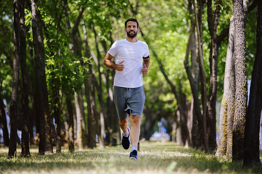 Beautiful young sports man running in nature Photograph by Milanvirijevic