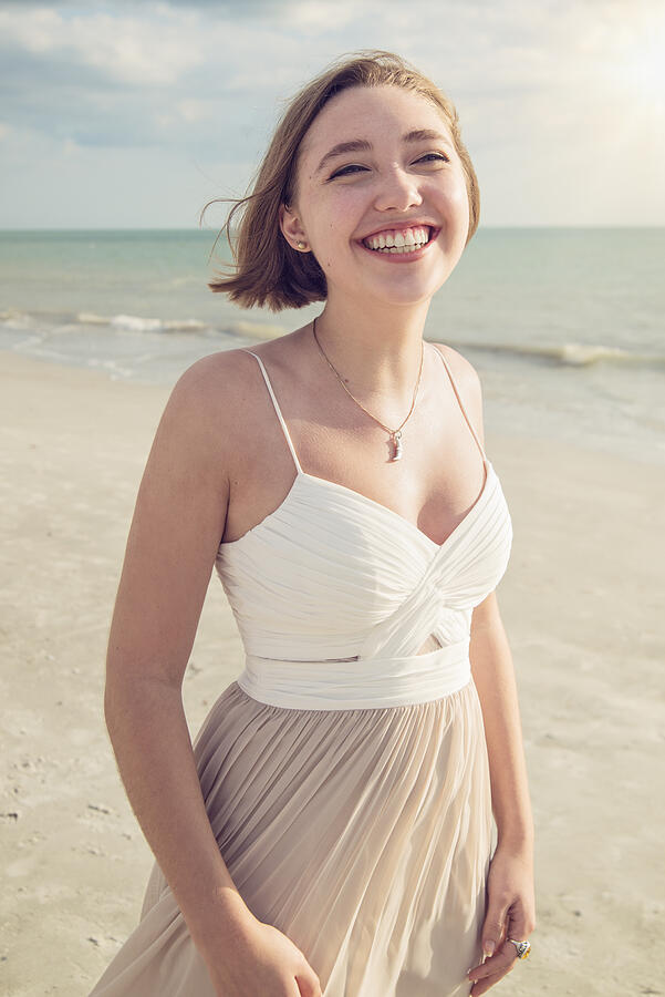 Beautiful young woman in prom dress on the beach. Photograph by Martinedoucet