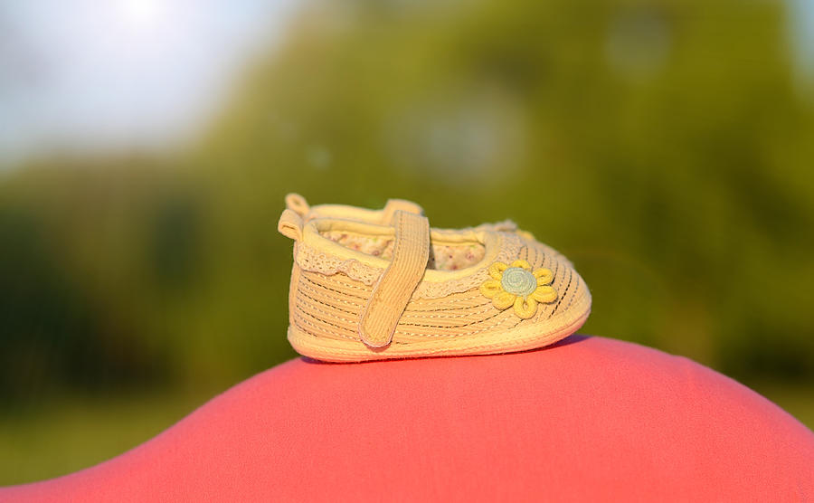 Beauty baby shoes on the mothers belly Photograph by Sssss1gmel