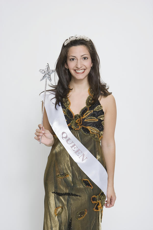 Beauty queen wearing sash, holding magic wand, smiling Photograph by Sheer Photo, Inc