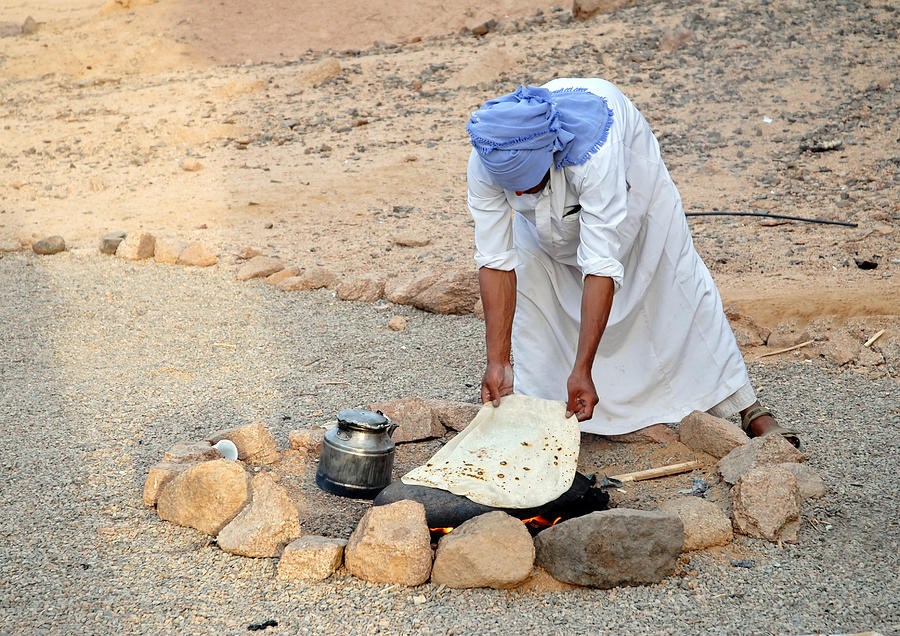 Bedouin baking bread on hot stone, Sinai Desert,Egypt Photograph by Brytta
