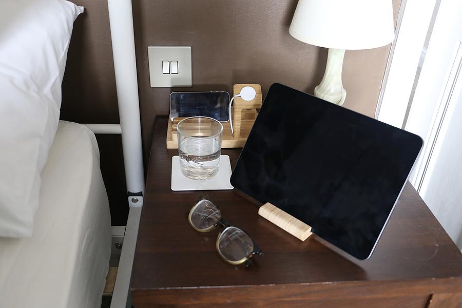 Bedside table with a tablet computer on it. Photograph by Emma Farrer