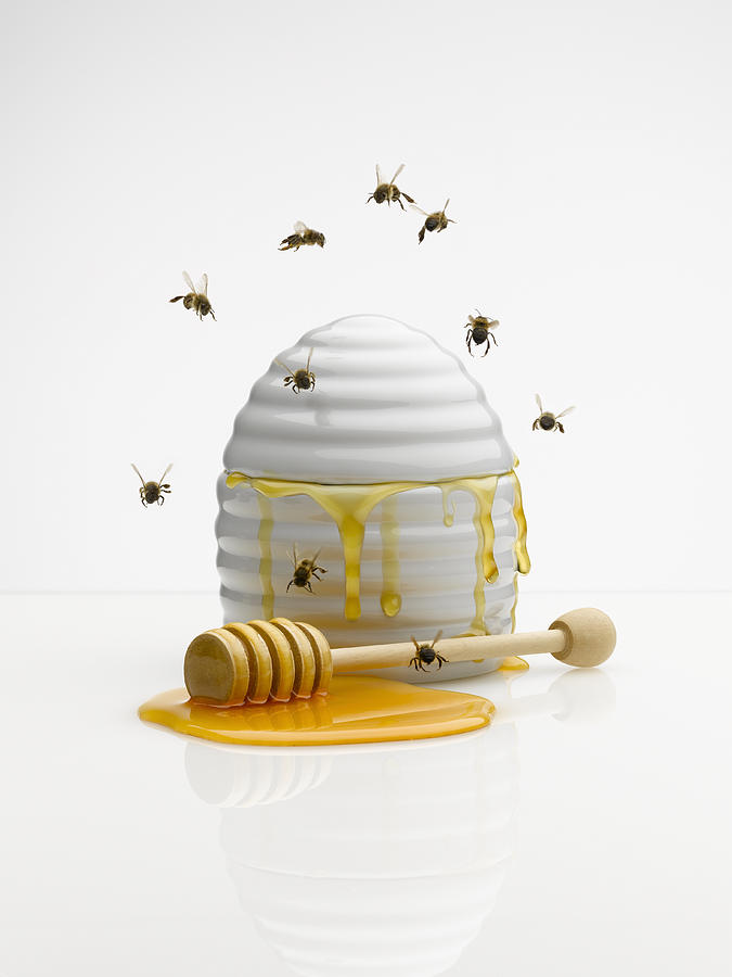 Bees flying around honey jar Photograph by Andy Roberts