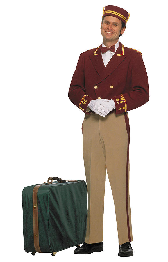 Bellboy with luggage Photograph by Comstock