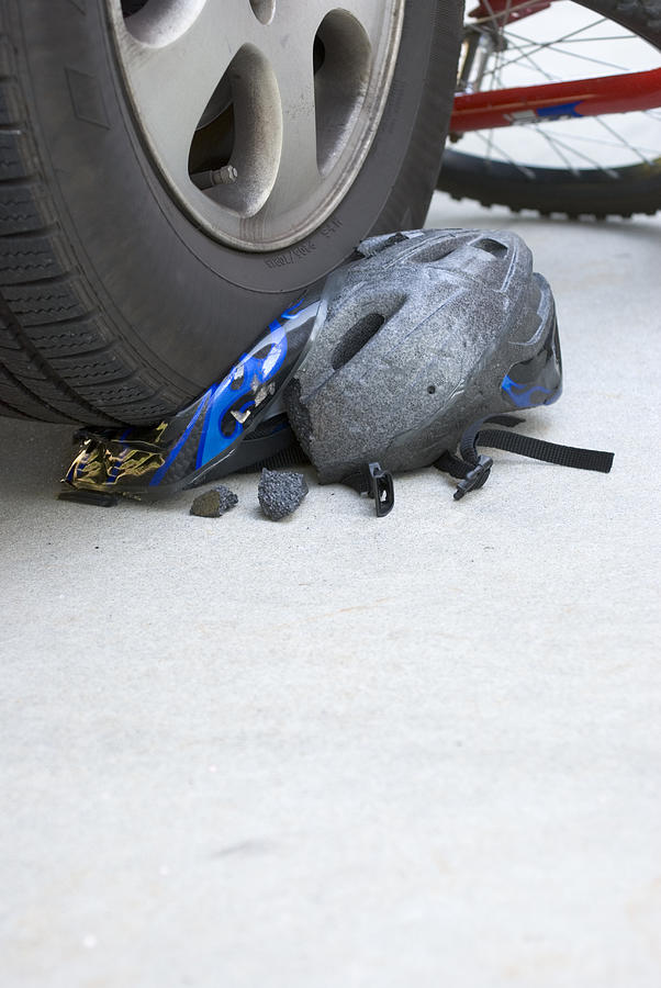 Bike Accident Helmet Crushed By Car Tire Vertical Photograph by Hkpnc