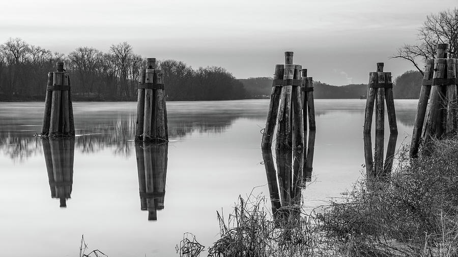 Black and White image of Calm reflections of docking piles on Connecticut river Photograph by Kyle Lee
