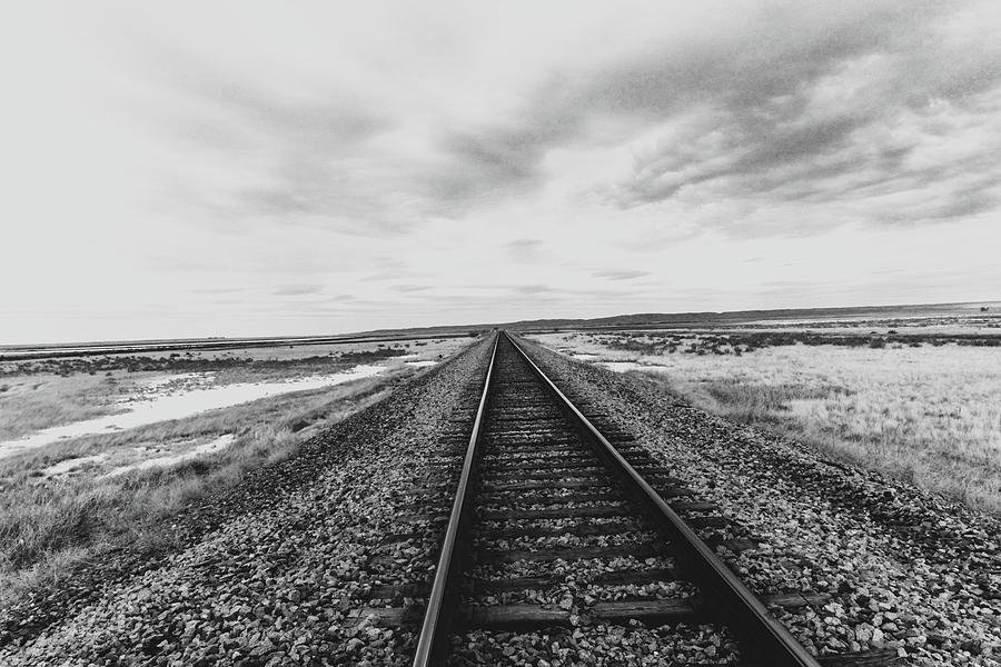 Black and white long straight train tracks Photograph by Jeff Swan