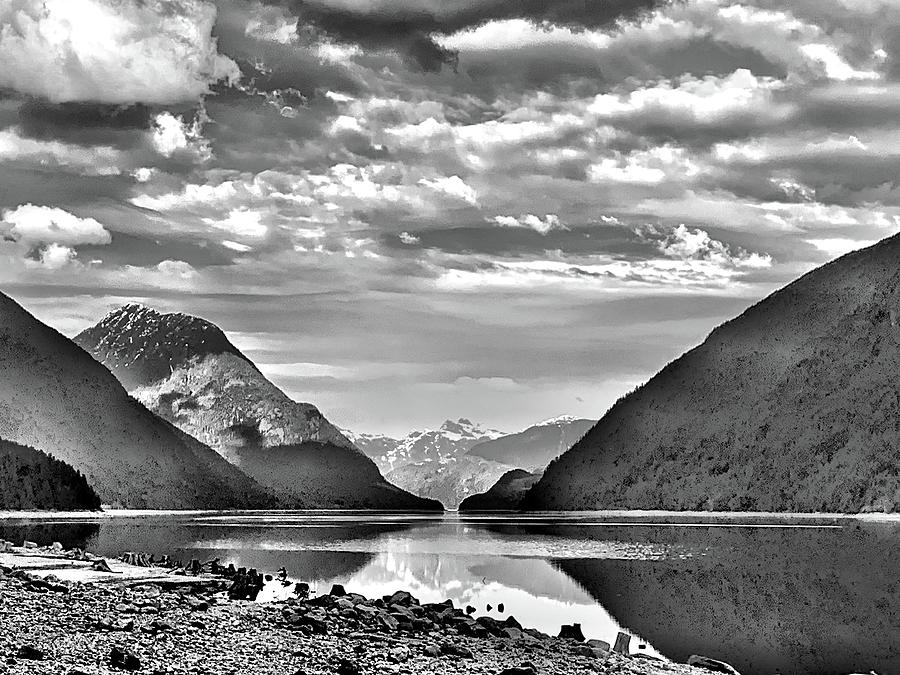 Black and white mountains and lake with dynamic sky and mirror ...