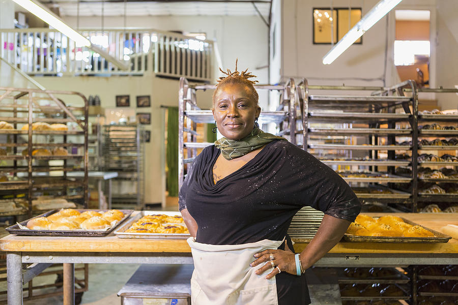 Black baker standing in bakery kitchen Photograph by Marc Romanelli