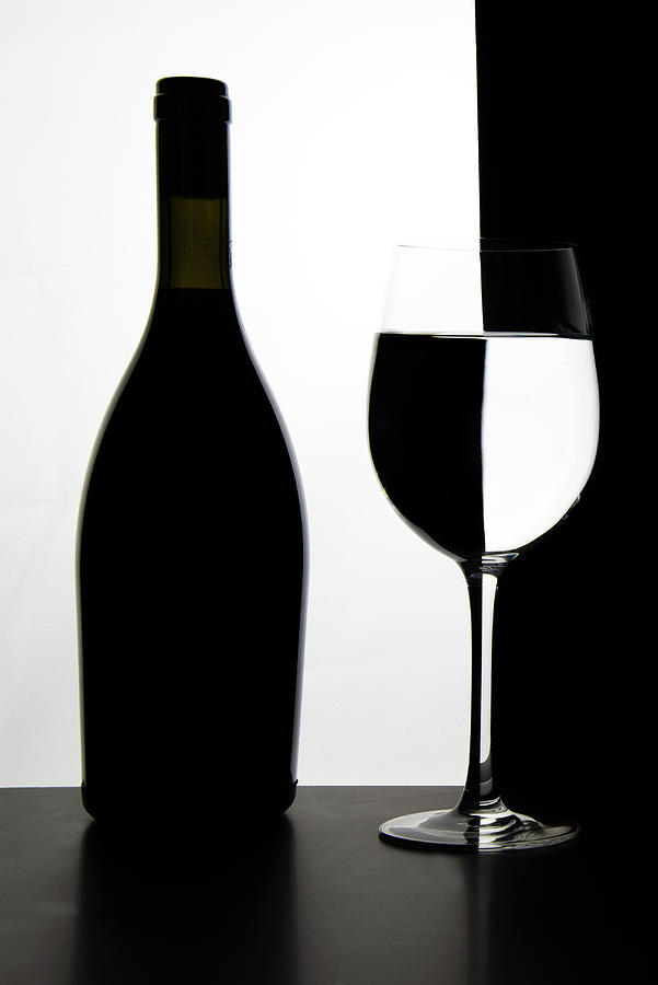 Black bottle and empty glass of wine Photograph by Michalakis Ppalis