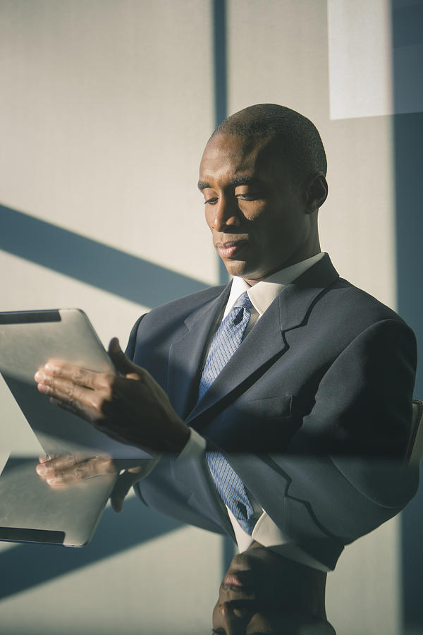 Black businessman using tablet computer Photograph by John Fedele