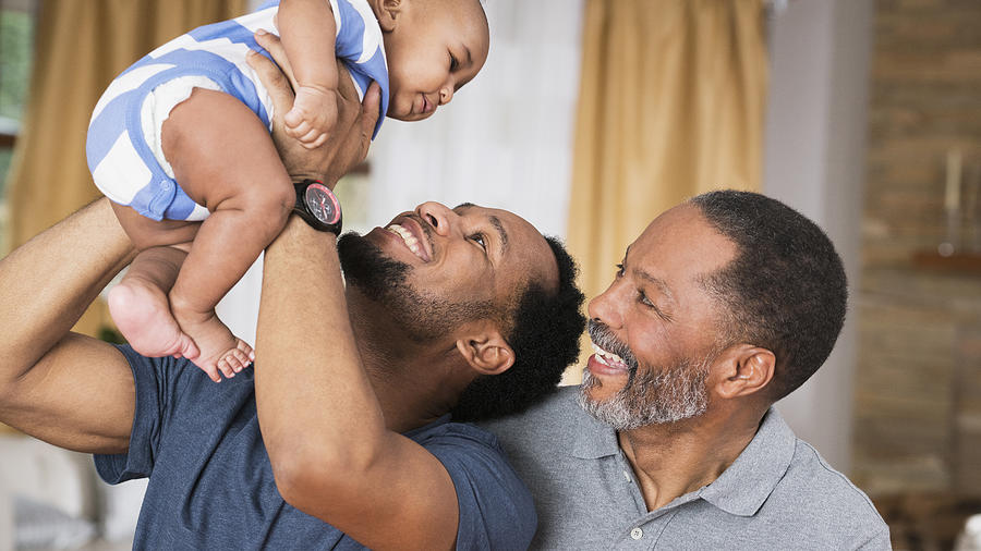 Black father and grandfather playing with baby boy Photograph by Ariel Skelley